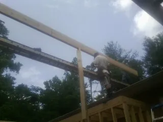 Carpenter setting a ridge beam over a new addition frame — Ice Dam Removal by Roofing Brothers in South Bend