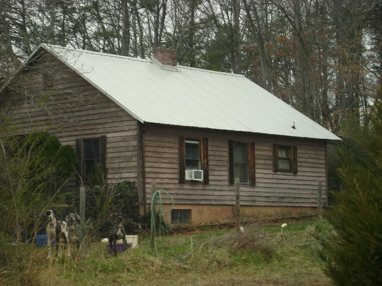 White metal roof on an old wood sided farmhouse, from a Metal Roof Installation job in South Bend